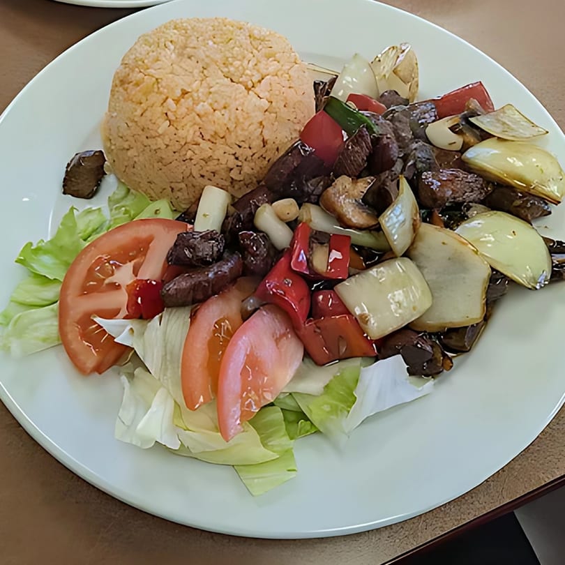 Pho Teresa's Vietnamese dish with fried rice, beef, bell peppers, onions, and a side salad.