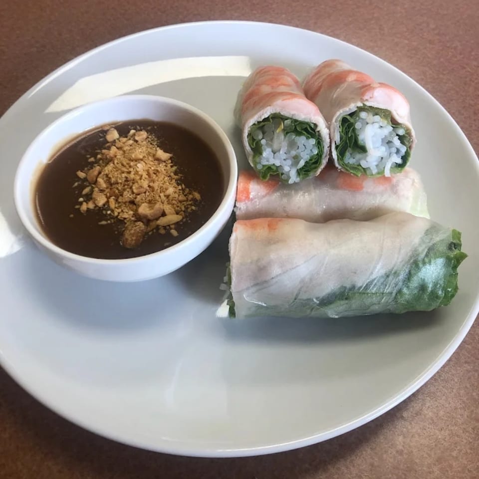 Fresh Vietnamese spring rolls with shrimp, rice noodles, and lettuce, served with peanut sauce.